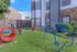 Inviting dog-friendly outdoor space with colorful play equipment and lush green grass, perfect for pets and relaxation.