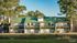 Charming apartment complex with green roofs, nestled among tall trees, offering a peaceful and scenic living environment.