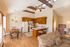 Inviting open-concept kitchen with wooden cabinets, cozy dining area, and comfortable seating under high ceilings with natural light.