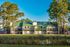 Charming apartment complex with green roofs nestled among tall pine trees, reflecting serene living in a natural setting.