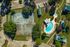 Stunning aerial view showcasing a luxurious community with a beautifully designed swimming pool, green recreational spaces, and surrounding amenities.