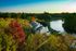 Serene lakeside townhouses surrounded by lush greenery and vibrant autumn foliage, offering a peaceful retreat with stunning nature views.