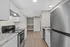 Modern kitchen with sleek stainless steel appliances, elegant granite countertops, and light wood flooring in an open-concept layout.