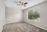 Inviting bedroom with plush carpet, large window with blinds, and a modern ceiling fan.