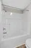 Modern bathroom featuring a sleek white bathtub with chrome fixtures, offering a clean and inviting space for relaxation.