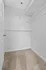 Spacious walk-in closet with white shelves and plush carpeting, ideal for organized living.