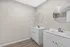 Modern bathroom with dual sinks, elegant round mirrors, and sleek white cabinetry, offering contemporary style and ample space.