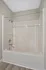 Sleek and modern bathroom with a pristine white bathtub-shower combination, accented by a stylish chrome faucet and showerhead.