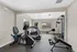 Bright and inviting home gym with modern exercise equipment, featuring cardio machines and strength training gear in a spacious, naturally lit room.