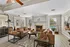 Inviting living room with elegant leather sofas, cozy fireplace, and expansive windows offering pool views.