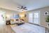Bright and inviting living room featuring modern decor, a cozy sofa, and elegant lighting, with natural light streaming through large French doors.