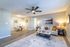 Modern open-concept living room with elegant sofa, ceiling fan, and cozy dining area featuring a stylish table setup.