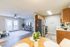 Inviting open-concept living area with elegant hardwood floors, sleek kitchen with stainless steel appliances, and cozy dining space with natural light.