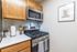 Modern kitchen corner with sleek stainless steel appliances, elegant wood cabinetry, and stylish decor. Perfect for culinary adventures.