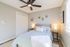 Bright and inviting bedroom featuring modern decor, cozy bed with soft pillows, elegant wall mirrors, and ambient lighting.
