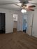 Inviting bedroom featuring plush carpet, elegant ceiling fan with lights, walk-in closet, and convenient bathroom access.