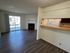 Charming open-concept living area with sleek laminate flooring, a cozy fireplace, and a sunlit sliding glass door leading outside.