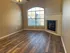 Charming living room with elegant fireplace, large window, and stylish wood flooring.
