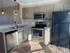 Modern kitchen with sleek stainless steel appliances, elegant granite countertops, and stylish pendant lighting.