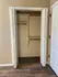 Spacious closet with double doors and stylish wooden flooring, ideal for organized living.