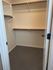 Spacious walk-in closet with dual hanging rods and built-in shelving, perfect for organized storage.