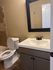 Elegant bathroom featuring a sleek vanity with a large framed mirror and a pristine bathtub, perfect for relaxation.