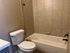 Chic bathroom with elegant tiled walls, spacious bathtub, and modern fixtures offering a luxurious feel.