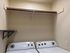 Modern laundry space featuring a sleek washer and dryer with convenient shelving above.
