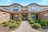 Inviting apartment facade with charming brickwork and lush greenery, highlighting a serene entrance.