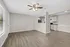 Bright and inviting open-concept living space featuring elegant hardwood floors, modern ceiling fan, and a sleek kitchen with ample cabinetry.