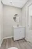 Chic bathroom vanity area featuring a modern white sink with a round mirror, complemented by wood-style flooring.