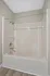 Elegant bathroom featuring a pristine white bathtub with modern fixtures and sleek flooring, perfect for relaxing after a long day.