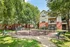 Charming apartment complex surrounded by lush greenery with inviting outdoor seating and modern architecture.