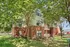 Charming apartment building surrounded by lush green trees, offering a serene and inviting atmosphere.