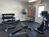 Modern home gym featuring state-of-the-art exercise equipment, including dumbbells, workout benches, and a cardio machine for a complete fitness experience.