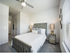 Inviting bedroom with a plush bed, elegant bedside lamps, and soft natural light streaming through blinds.