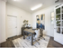 Elegant office space with modern decor, featuring a wooden desk, plush chairs, abstract artwork, and stylish lighting.