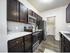 Modern kitchen with sleek dark wood cabinets, stainless steel appliances, and elegant marble countertops.