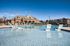 Inviting outdoor pool with elegant lounge chairs, adjacent to a charming brick clubhouse under a clear blue sky.
