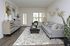 Chic living room featuring a modern gray sofa, stylish decor, and a contemporary coffee table, bathed in natural light through large windows.