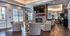Luxurious living room with stylish patterned chairs, a stone fireplace, and elegant wood flooring, perfect for gatherings.