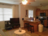 Cozy open-concept apartment featuring a warm living area with a sleek ceiling fan, stylish kitchen with wooden cabinetry and modern appliances, and a comfortable seating arrangement perfect for relaxation.