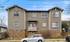 Charming two-story apartment building with rustic stone foundation and contemporary siding, featuring quaint windows and a welcoming front entrance.