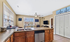 Bright and inviting kitchen with granite countertops, stainless steel appliances, and a spacious open design overlooking a cozy living area with large windows.