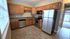 Charming kitchen with warm wood cabinets, sleek stainless-steel appliances, and abundant natural light for a cozy yet modern feel.