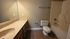 Inviting bathroom with elegant countertop, spacious mirror, and modern fixtures for a touch of luxury.
