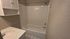 Bright and modern bathroom showcasing a pristine white bathtub, elegant wall tiles, and ample shelving for storage.
