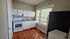 Charming kitchen with modern appliances, plenty of natural light, and warm hardwood floors for a cozy cooking experience.