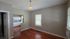 Charming living space with warm wooden flooring, adjacent to a bright kitchen with modern cabinetry and ample natural light.