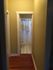 Inviting hallway with warm lighting leading to a cozy bathroom featuring classic white tiles and a shower curtain.